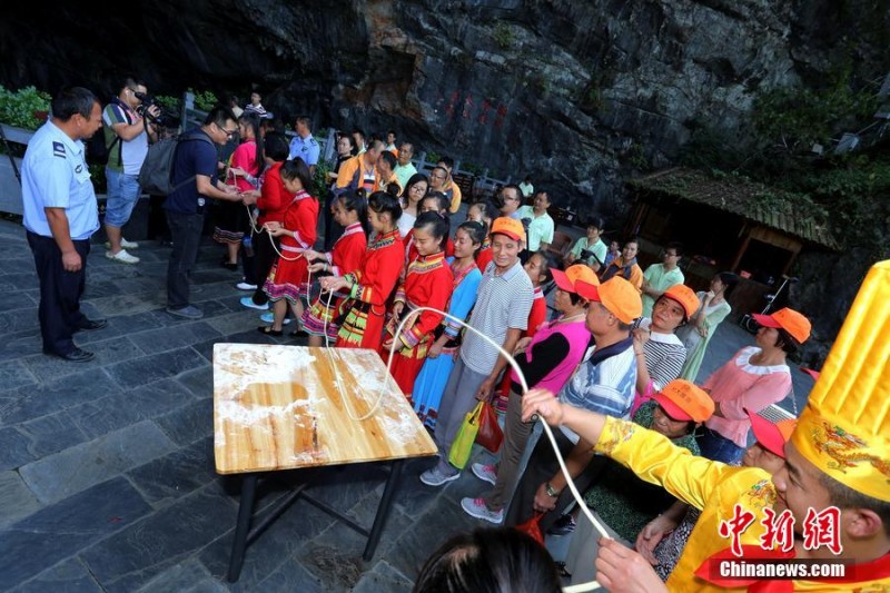 广东连州拉出"万米长寿面" 游客搭着梯子挑面吃