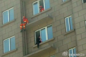命悬一线！消防员“飞脚”营救欲跳楼女子(组图)