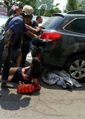 女子马上要被车碾过 路人一齐冲上去(组图)